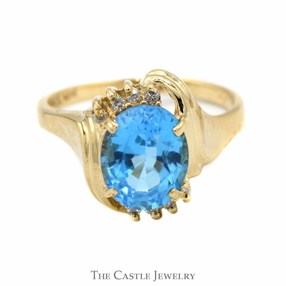 Artistic Ornament Oval Blue Topaz Ring with Diamond Accented Bypass Mounting in 14k Yellow Gold